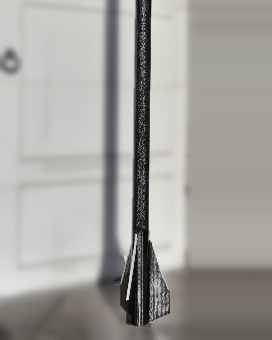 ION 3.2 standing on the driveway, the 75 mm carbon airframe and its fin can sharp against a defocused garage door