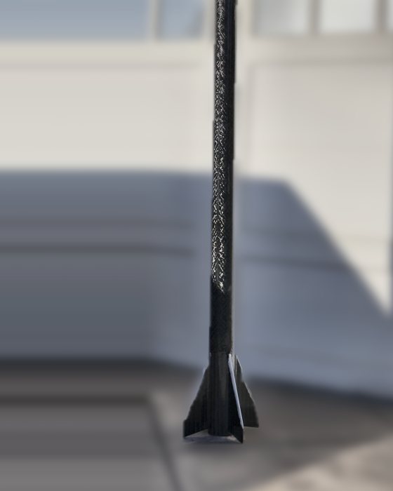 ION 4.4 standing on the driveway outside the garage it was built in, the fin can and woven carbon sharp against a defocused door
